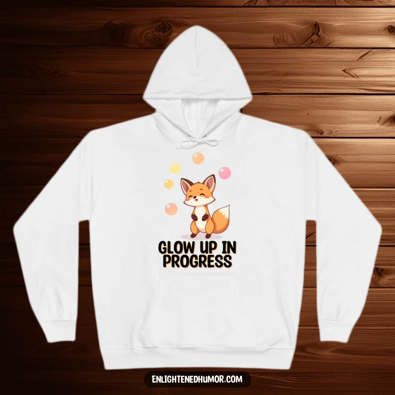 Funny hoodie featuring a playful fox juggling glowing orbs, offering humorous warmth and magical charm.