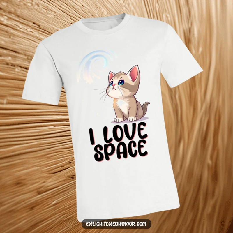 Funny t-shirt showing a curious kitten captivated by swirling, luminous celestial patterns above, full of wonder.